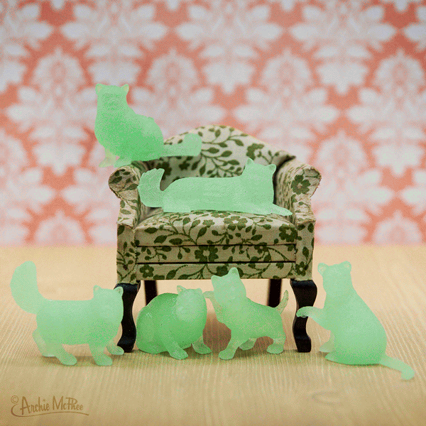 A set of small, glow-in-the-dark cat figures, each with unique poses and features.