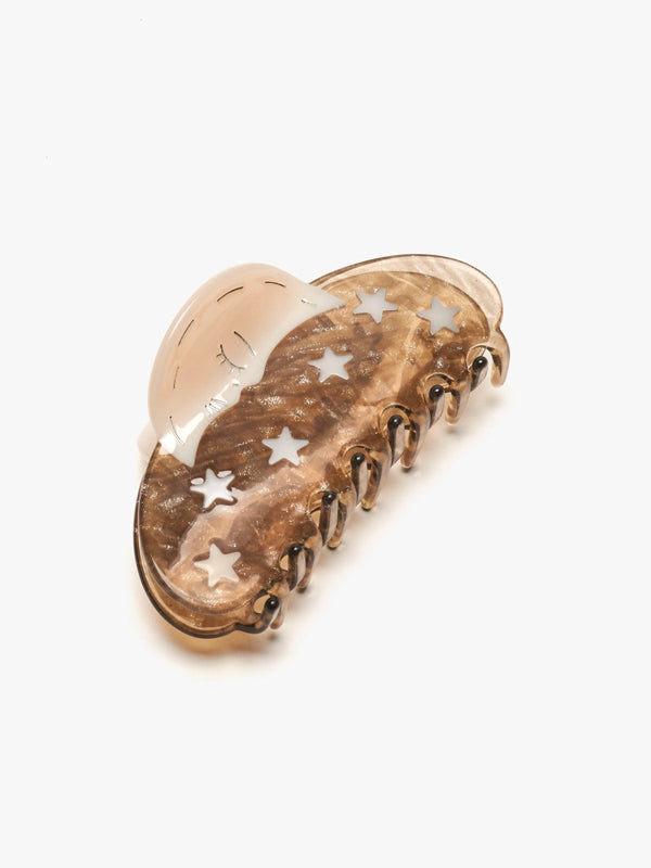 A silver sparkle claw hair accessory featuring delicate moon and star motifs. The claw has a shimmering finish, adding a touch of celestial charm to any hairstyle while securely holding hair in place.