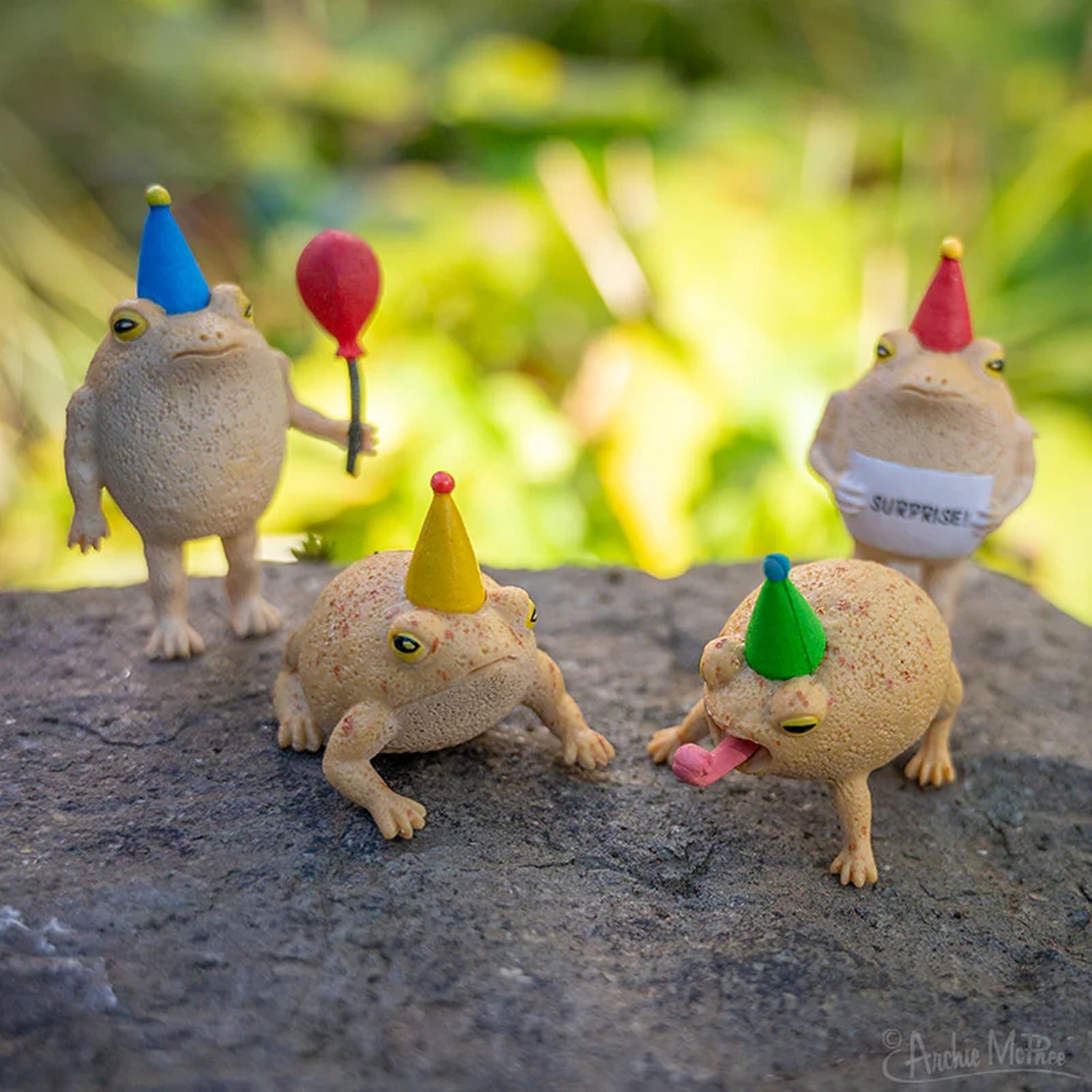 A collection of vibrant frog figurines dressed in party attire, holding tiny party hats and balloons, ready to celebrate.