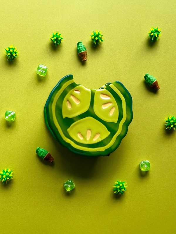 A fun pickle-shaped chip clip designed to keep snacks fresh, featuring a vibrant green color and playful pickle design for a whimsical touch in your kitchen.