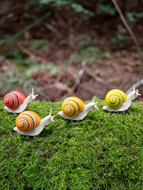 Racing snail figures featuring cute, whimsical snails in dynamic racing poses, perfect for playful decoration or imaginative play.