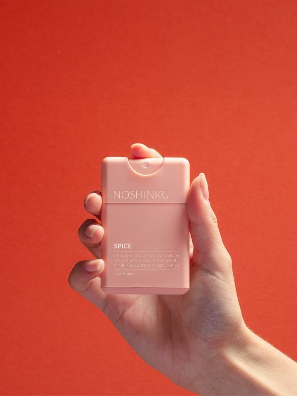 Pocket sanitizer in a refreshing orange and coriander scent, featuring a compact bottle that's perfect for on-the-go cleansing and a burst of fresh fragrance.